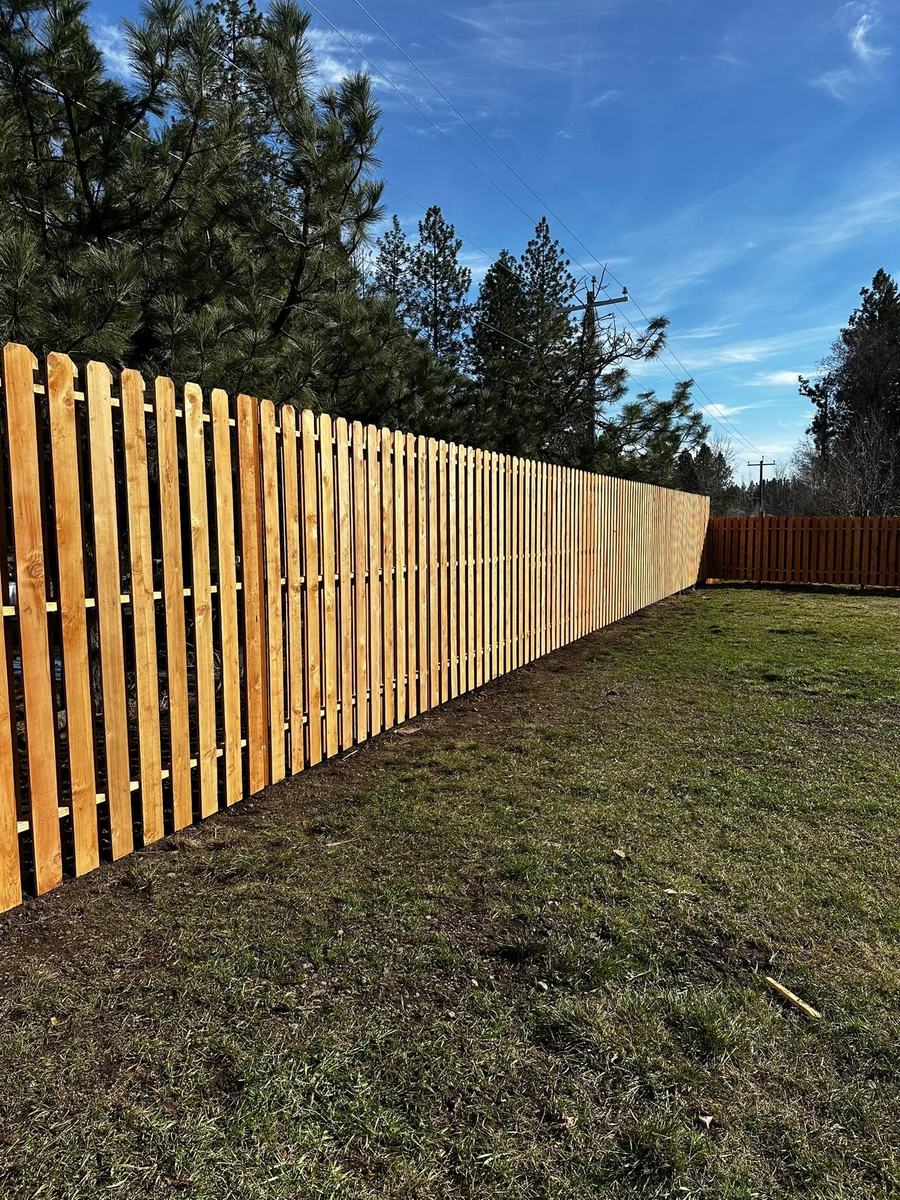 Long run of shadow box cedar fence along a property line