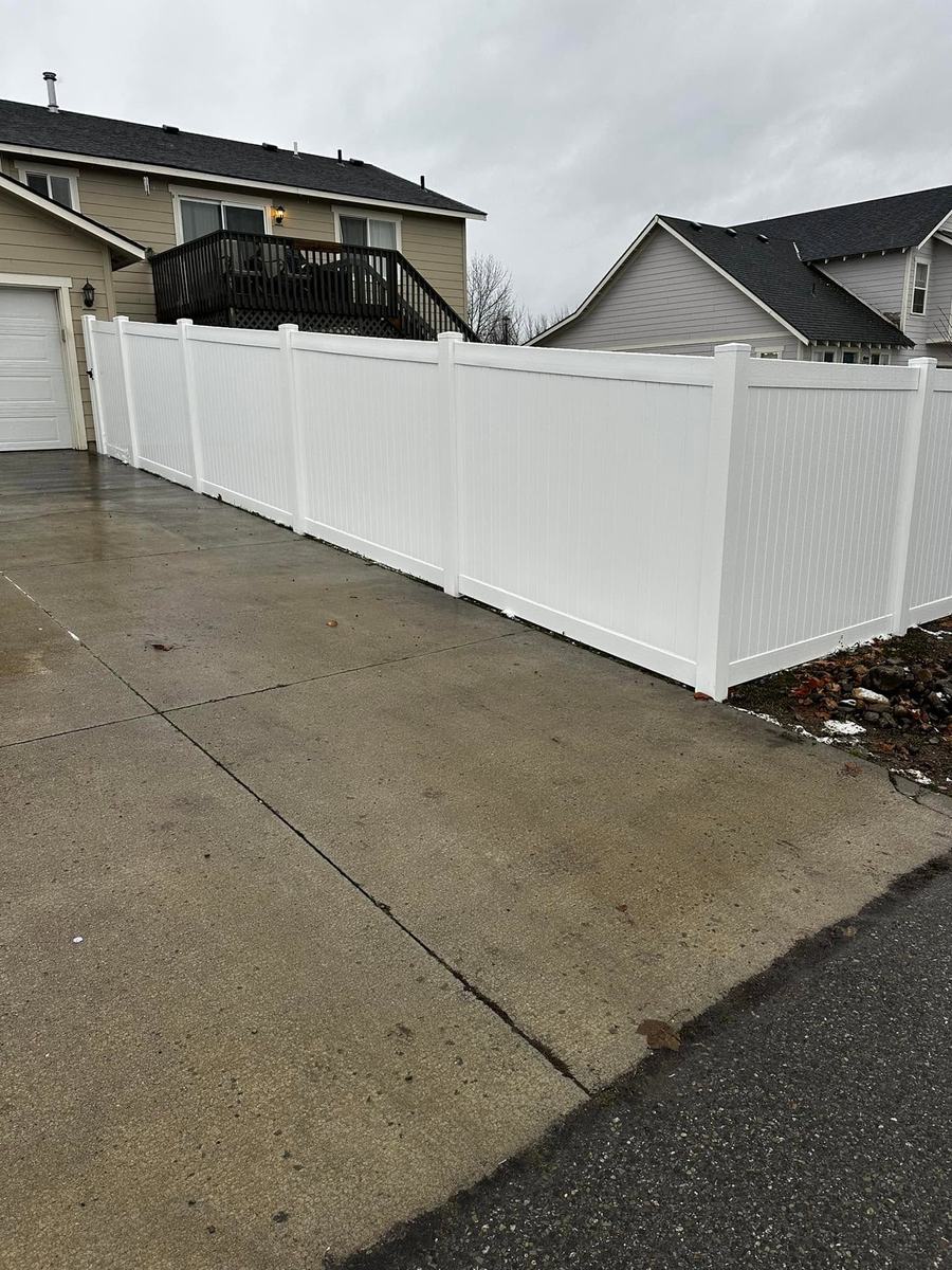 White vinyl privacy fence along a driveway